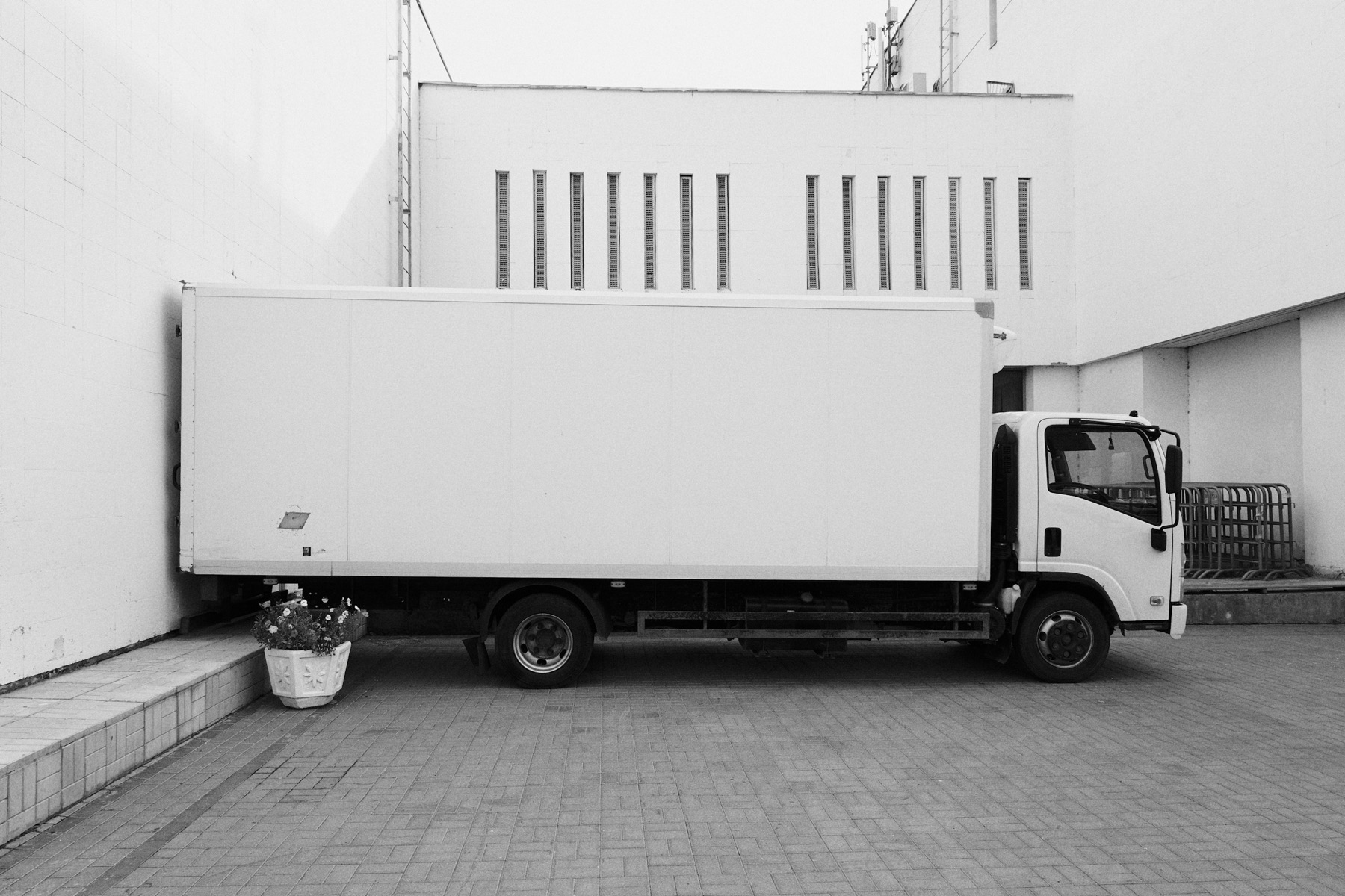 Weisser Lastwagen vor einer Halle